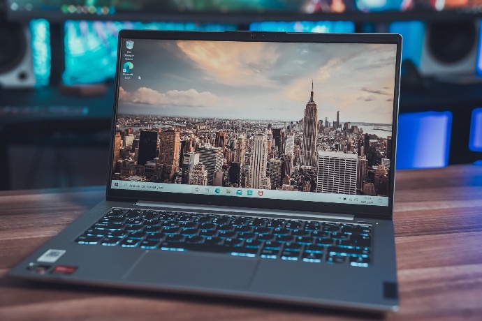 black laptop computer turned on displaying city skyline